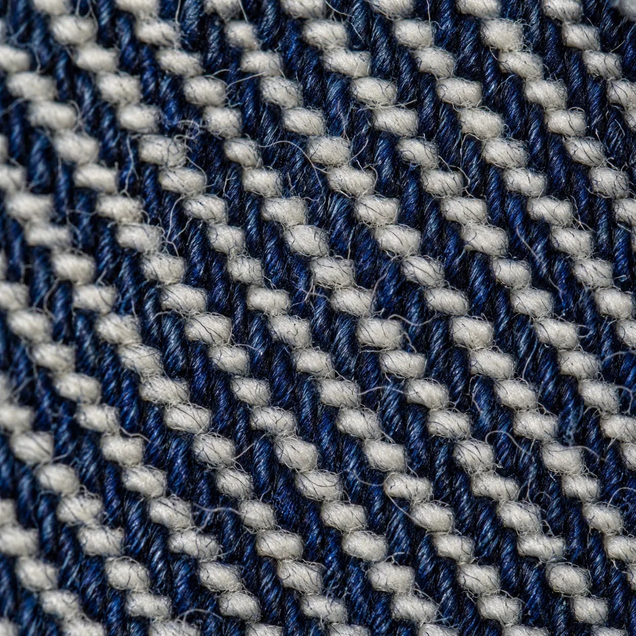 Extreme macro of indigo denim twill, blue warp crossing white weft.