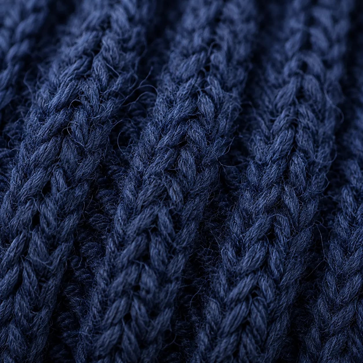 Extreme macro of deep indigo merino rib knit with a soft fibre halo.
